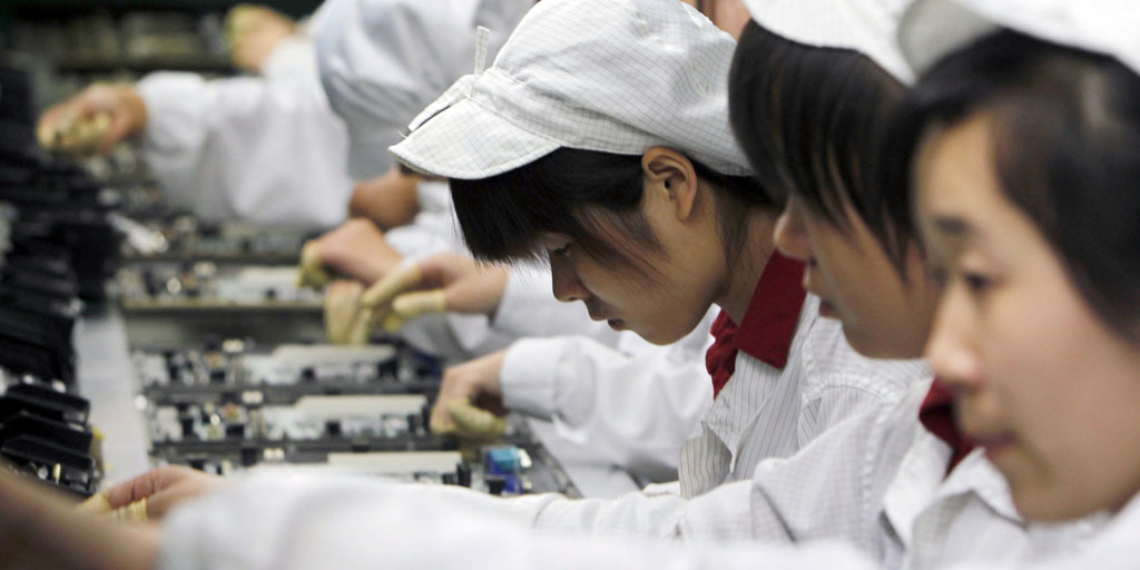 FILE-In this Wednesday, May 26, 2010, file photo, staff members work on the production line at the Foxconn complex in Shenzhen, China. Foxconn, the company that makes Apple’s iPhones suspended production at a factory in China on Monday, Sept. 24, 2012, after a brawl by as many as 2,000 employees at a dormitory injured 40 people. The fight, the cause of which was under investigation, erupted Sunday night at a privately managed dormitory near a Foxconn Technology Group factory in the northern city of Taiyuan, the company and Chinese police said.(AP Photo/Kin Cheung, File)