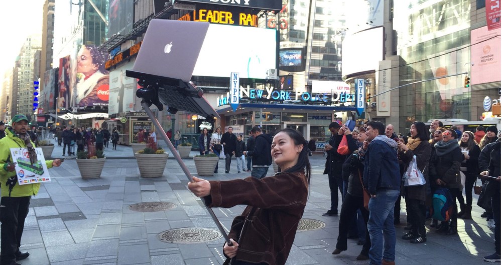 Girl using MacBook Selfie Stick in Times Square