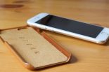 Mujjo Leather Case in Tan with an iPhone 6 propped up against it