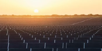 Backlit sunset photo of large solar farm | Apple supply chain doubled its use of clean energy last year