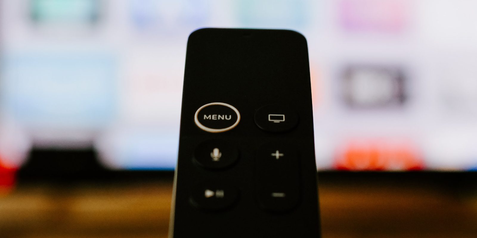 Apple TV remote in front of out-of-focus TV screen | Netflix has no USP, says analyst, against quality for Apple TV+