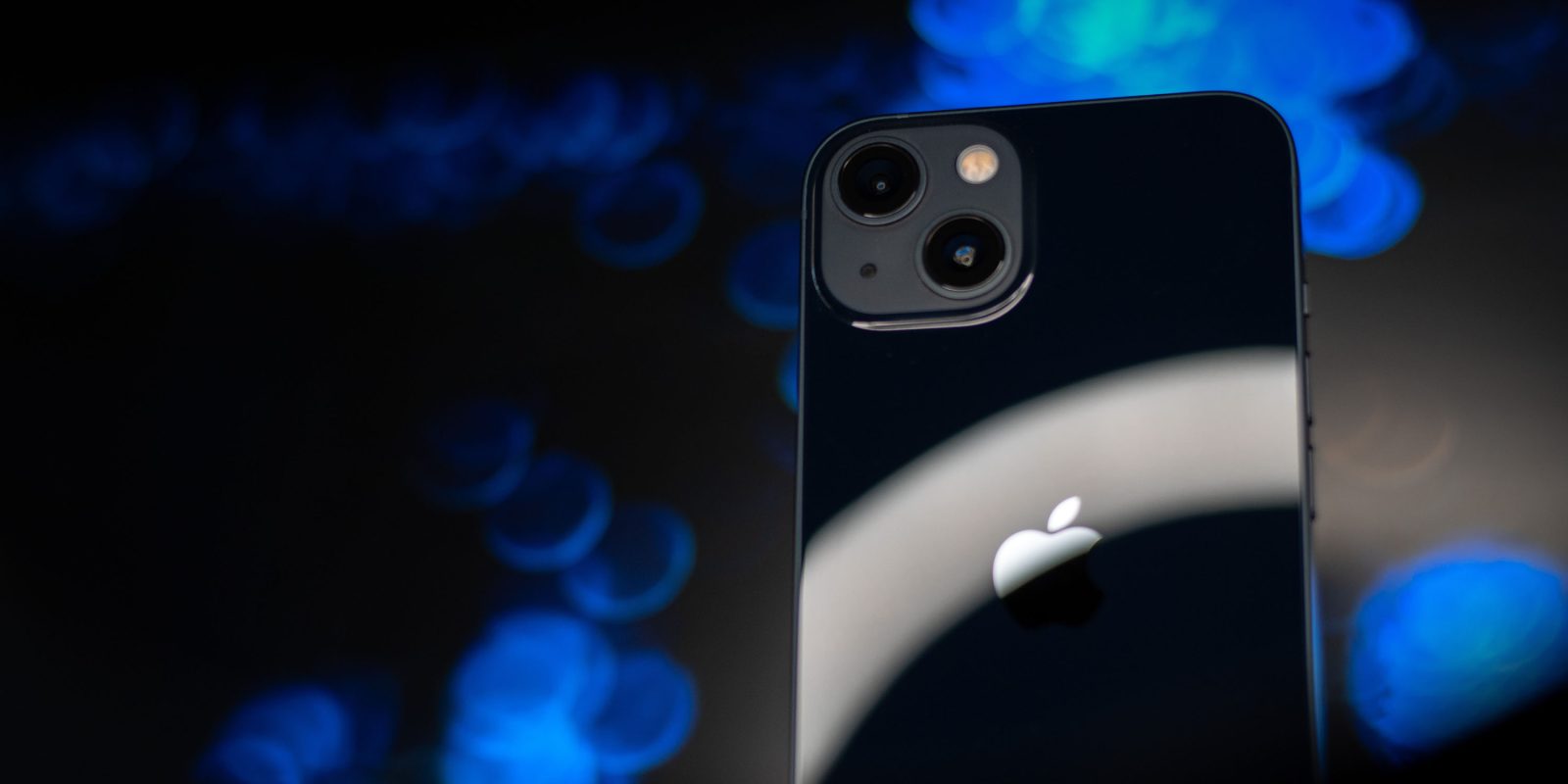 Black iPhone 13 shown against abstract background | Pegasus targeted US iPhones indirectly