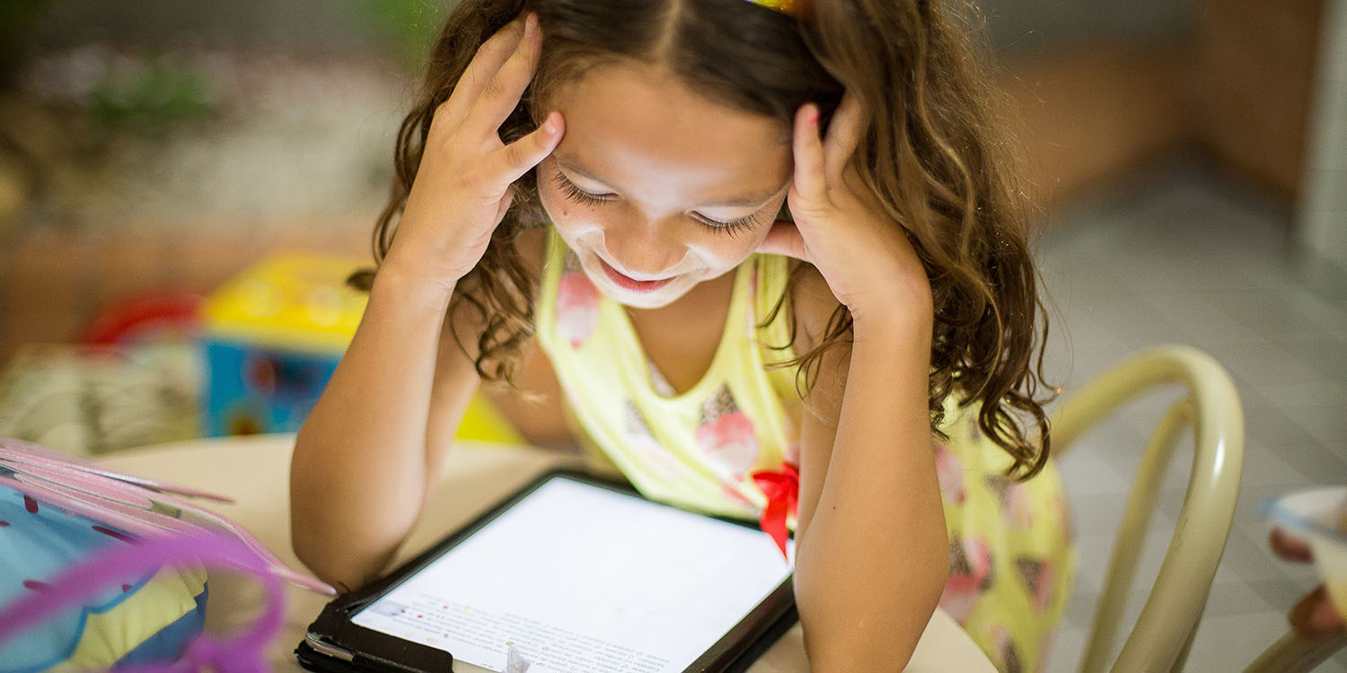 Young girl using an iPad | Bipartisan deal brings cheaper broadband to tens of millions of Americans