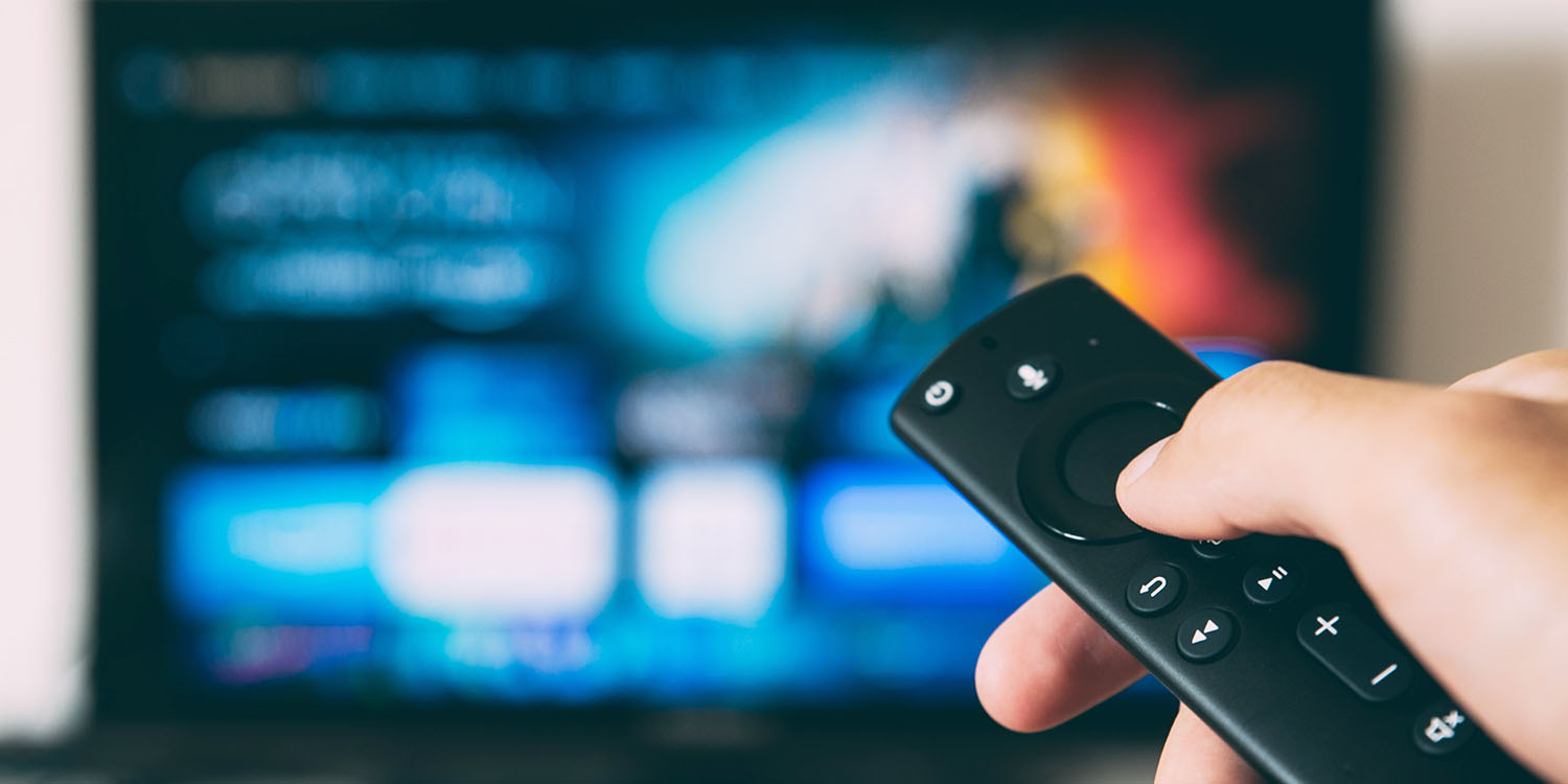 Video streaming services | Apple TV remote with out-of-focus TV in the background