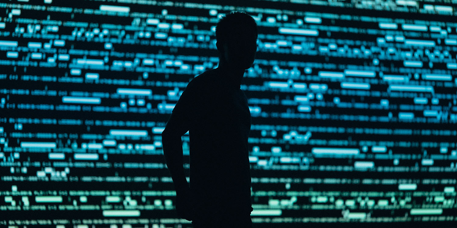 Spyware company | Abstract image of silhouetted person against data