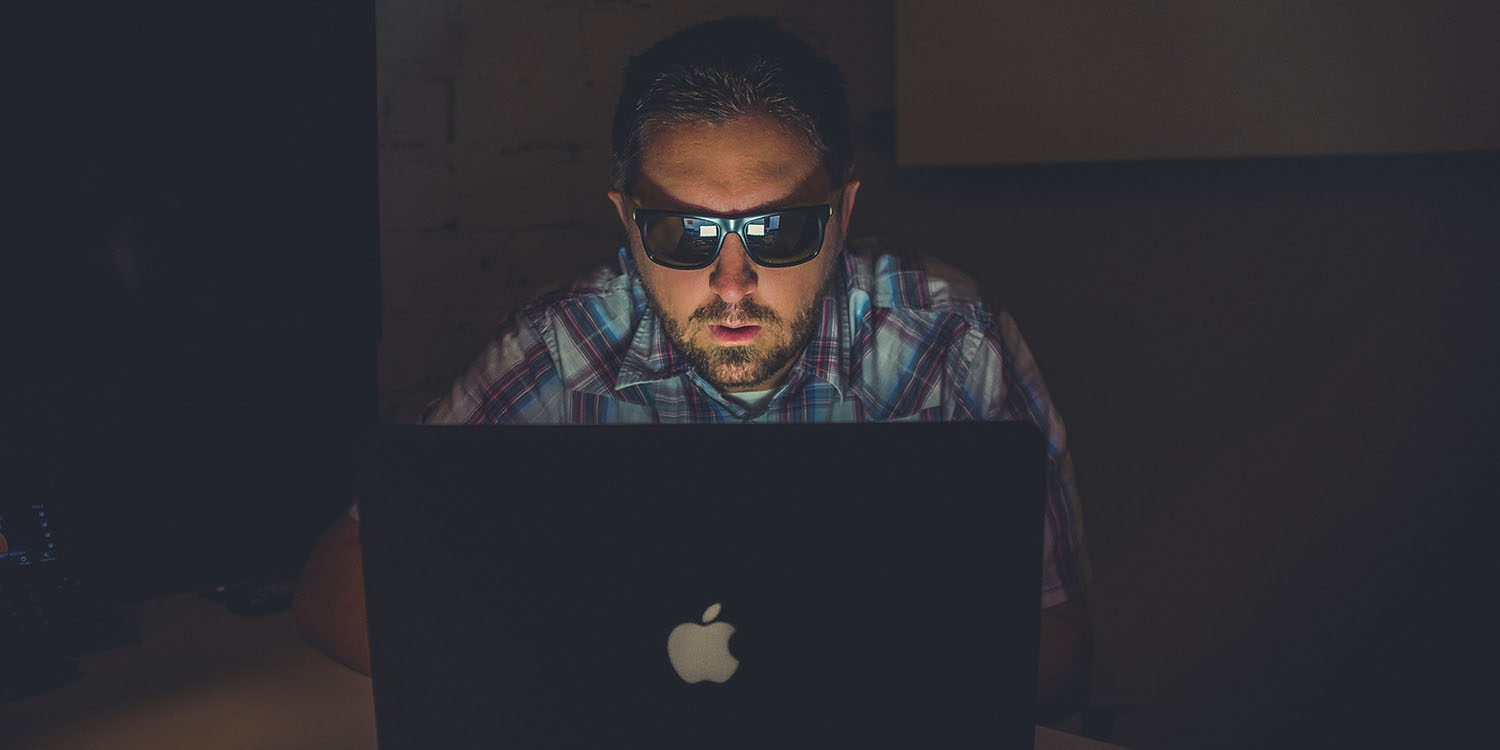 Twitter toxic | Man wearing sunglasses to look at laptop screen