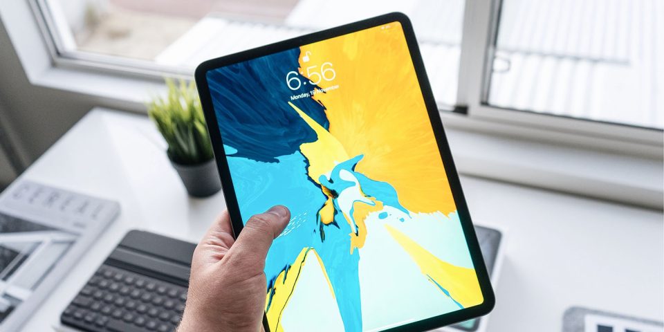 First OLED iPad | iPad Pro held in hand above desk
