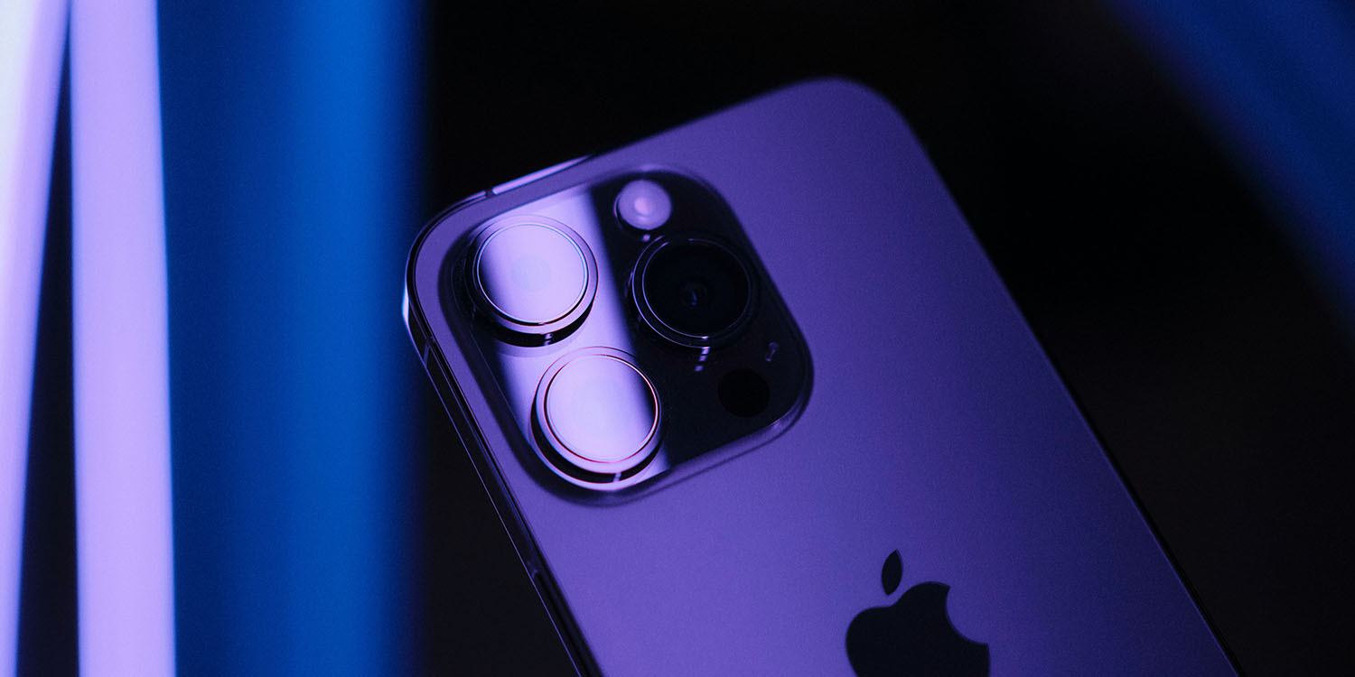 iPhone 14 Pro demand | Phone seen under purple lighting