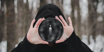 iMessage Contact Key Verification blocks the 'ghost proposal' | Robed figure holds an object with a ghost in it