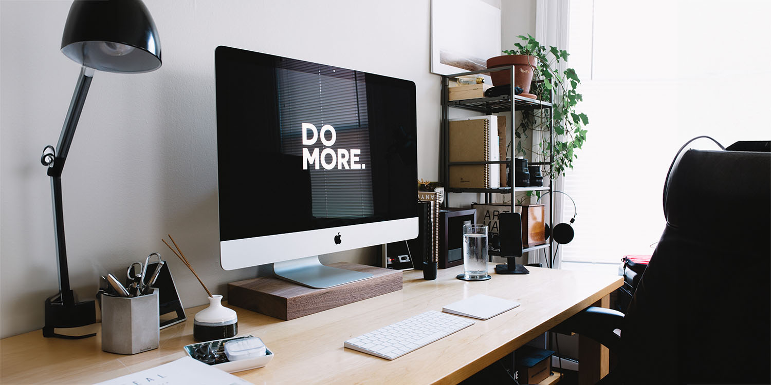 Bringing AI to Mac | iMac on desk with 'Do More' screensaver