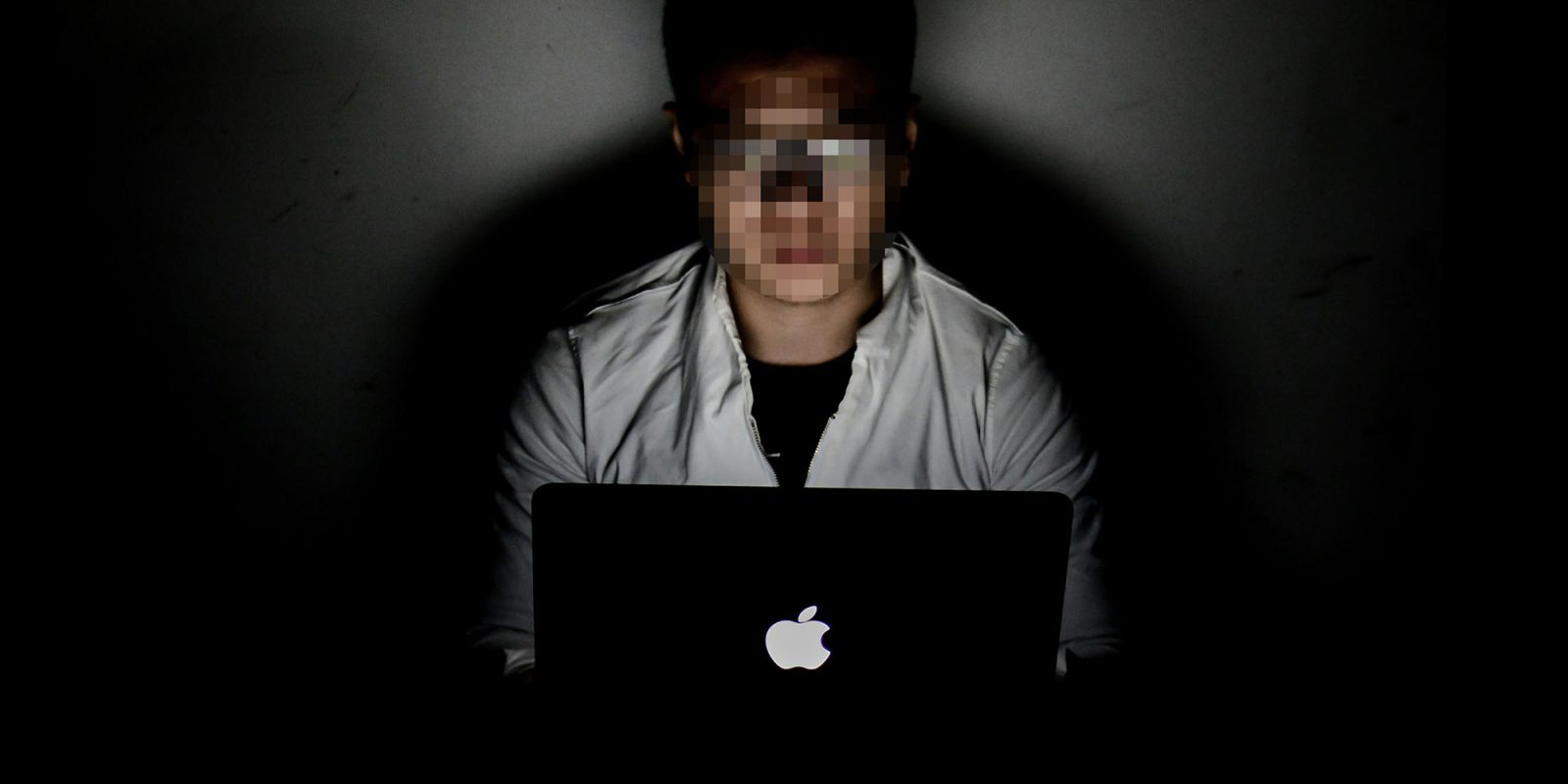 TikTok hack compromised CNN account | Conceptual image of pixellated face working on MacBook in the dark