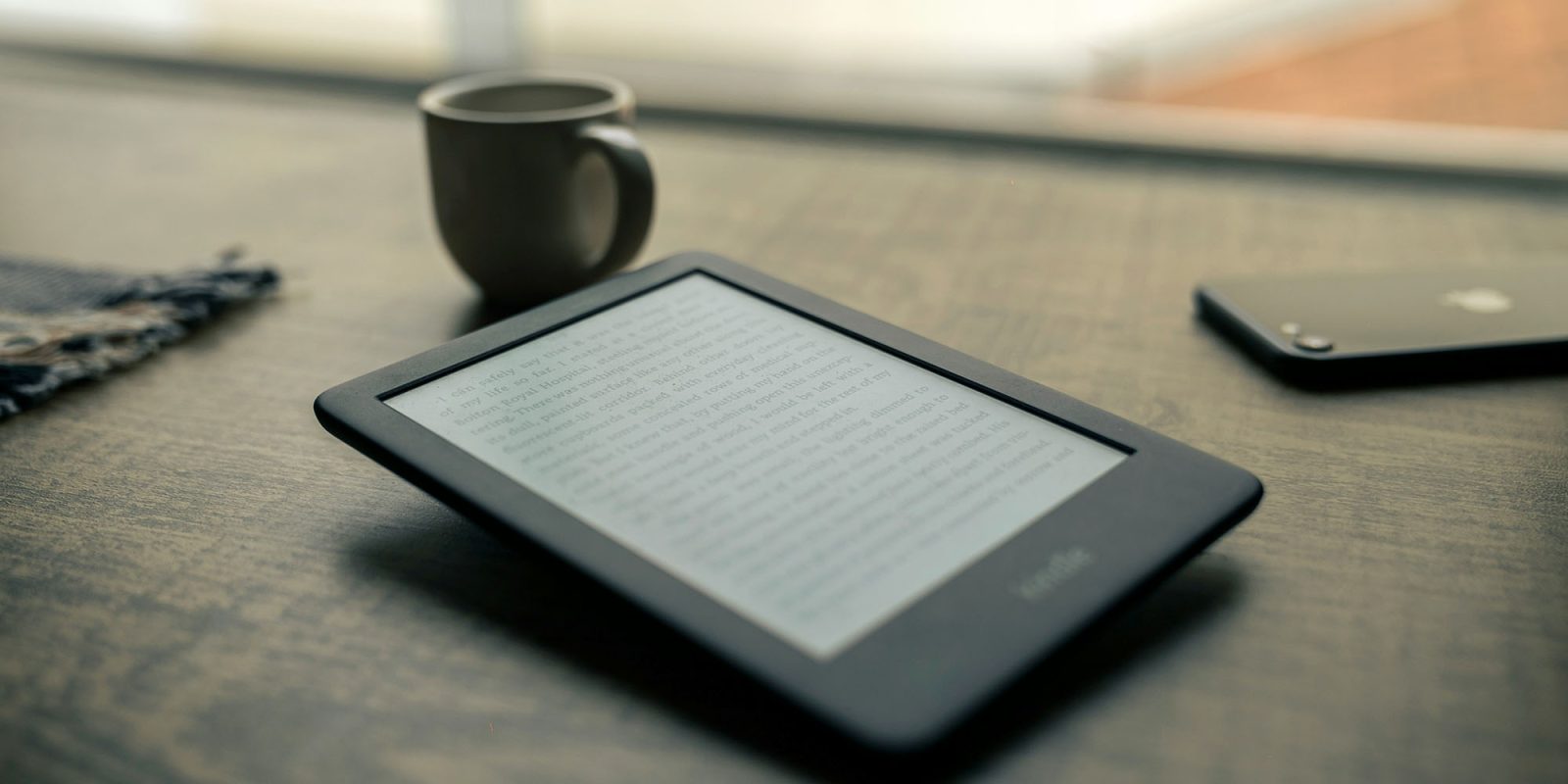 Kindle won't download books | Kindle and iPhone on desk