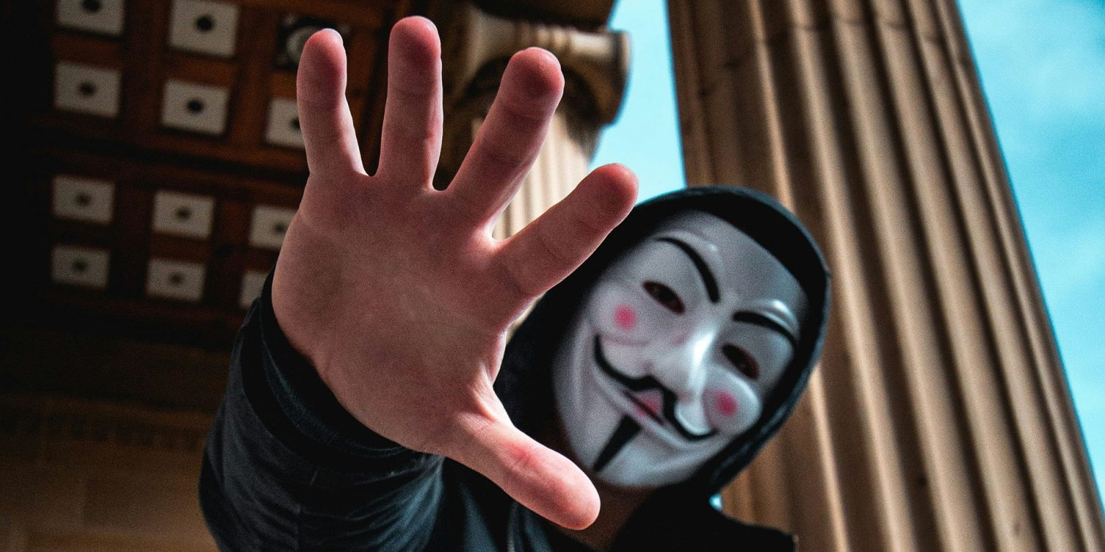 MoneyGram hack | Masked man reaching out with grasping hand