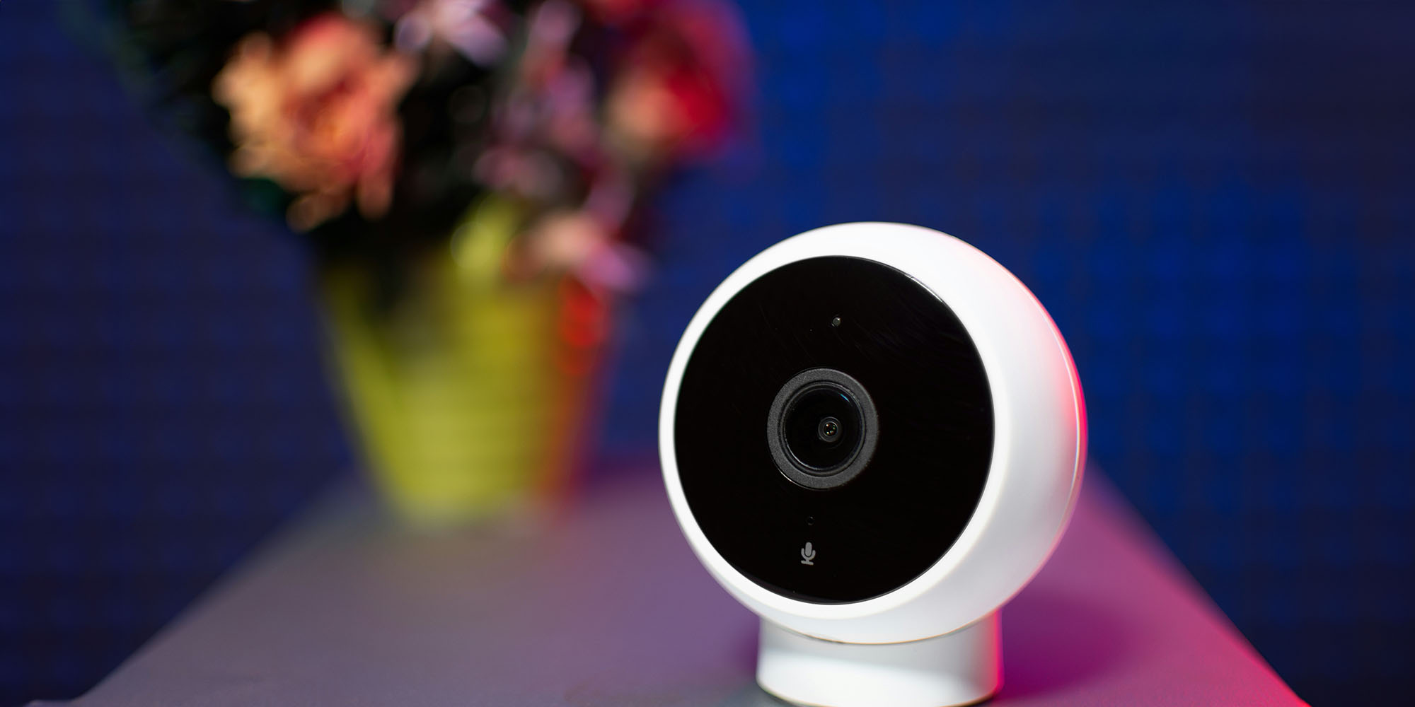 An Apple smart home camera will combine privacy with Apple Intelligence (Xiaomi camera shown on desk with flowers in vase)