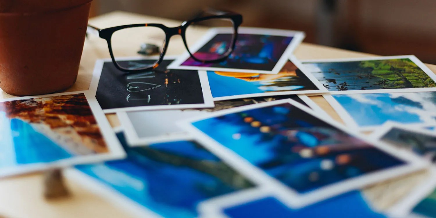 CSAM victims sue Apple for $1.2B for dropping planned scanning tool | Photo shows eyeglasses and photos on a table