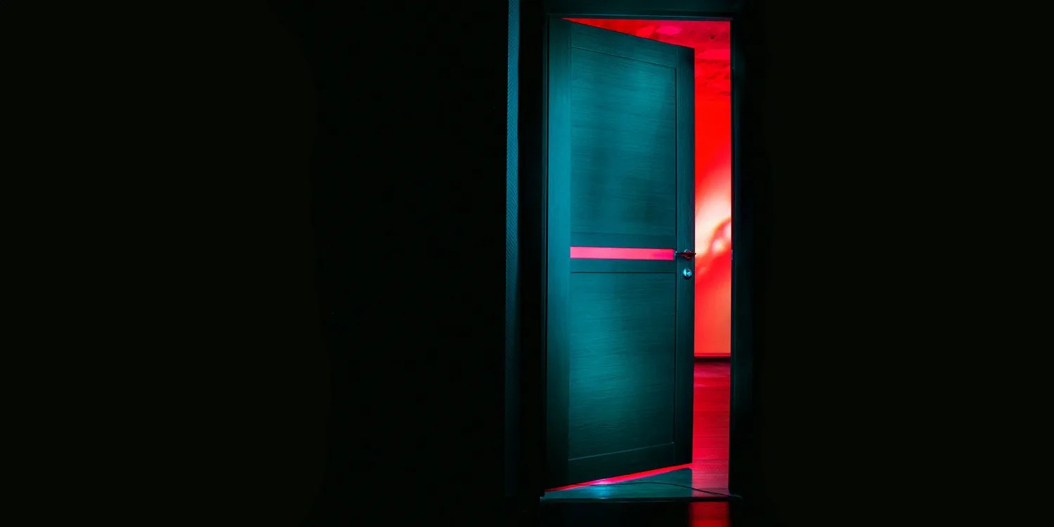 British government secretly ordered Apple to create a worldwide iCloud backdoor | Photo shows partly-open door with a red room beyond it