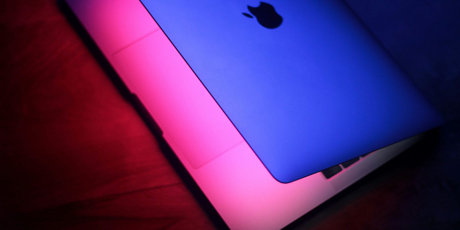 MacSync Stealer finds a way to bypass Apple malware protections | Partially open MacBook, shown with blue and pink lighting